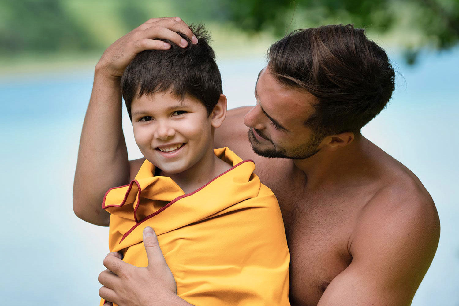 Mann und Kind vorm See mit Mikrofaser Handtuch von Fit-Flip