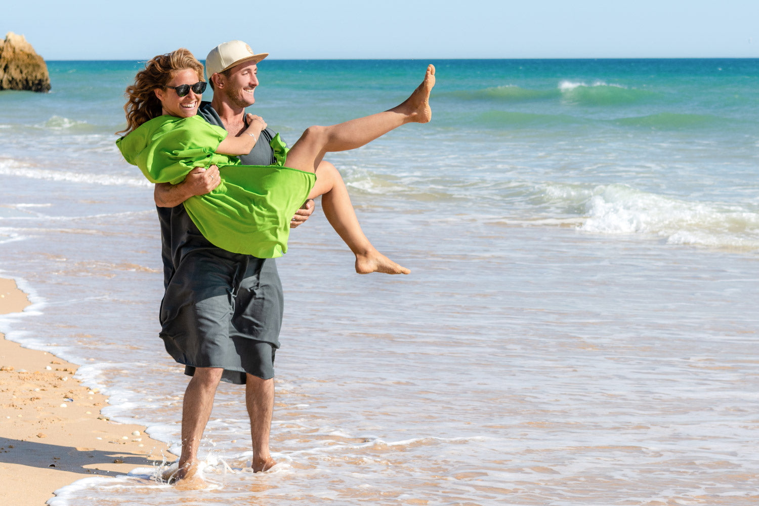 Mann und Frau mit Fit-Flip Handtuch Poncho aus Mikrofaser am Strand