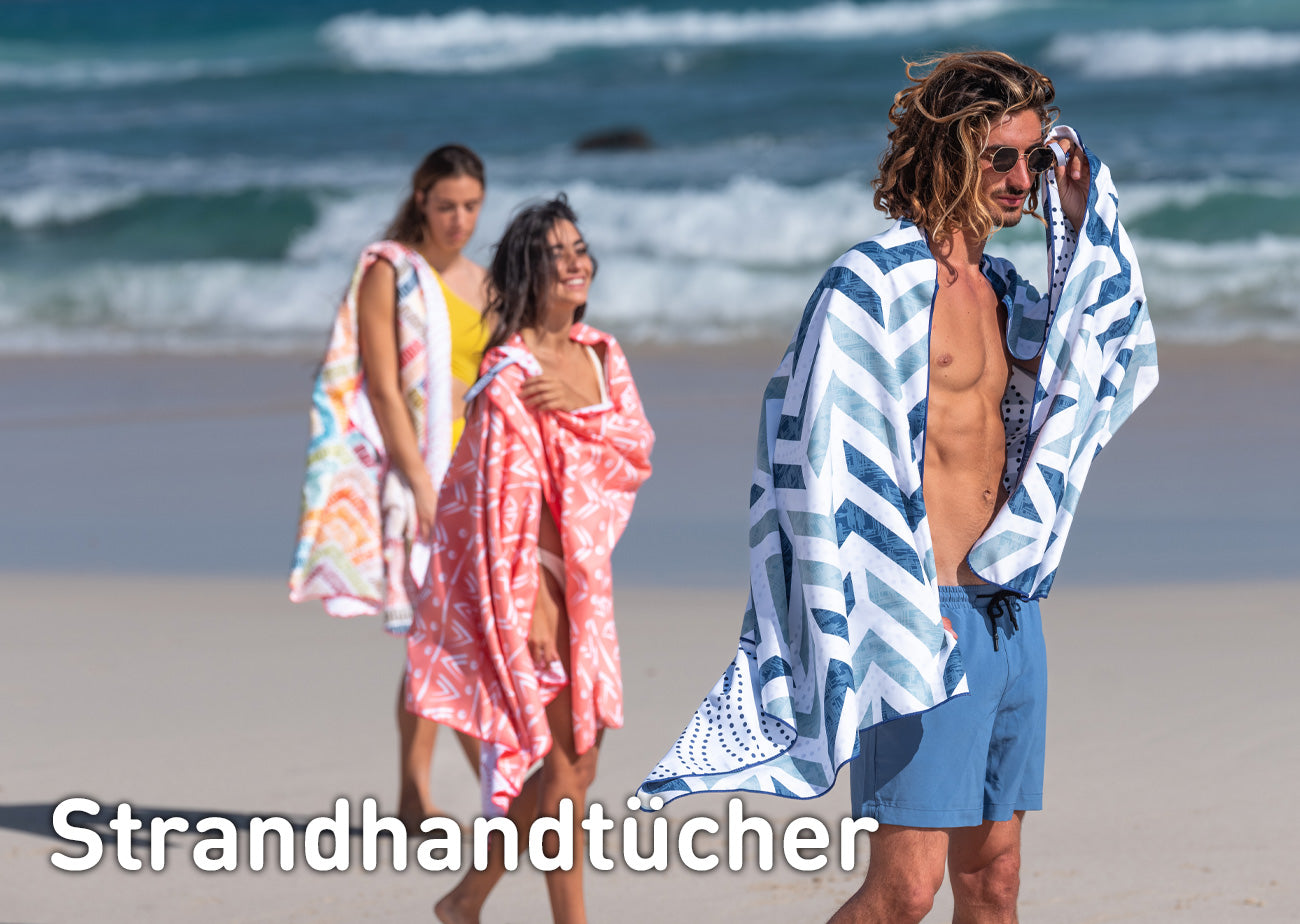 Mann und zwei Frauen mit Fit-Flip Strandhandtuch XXL aus Mikrofaser am Strand